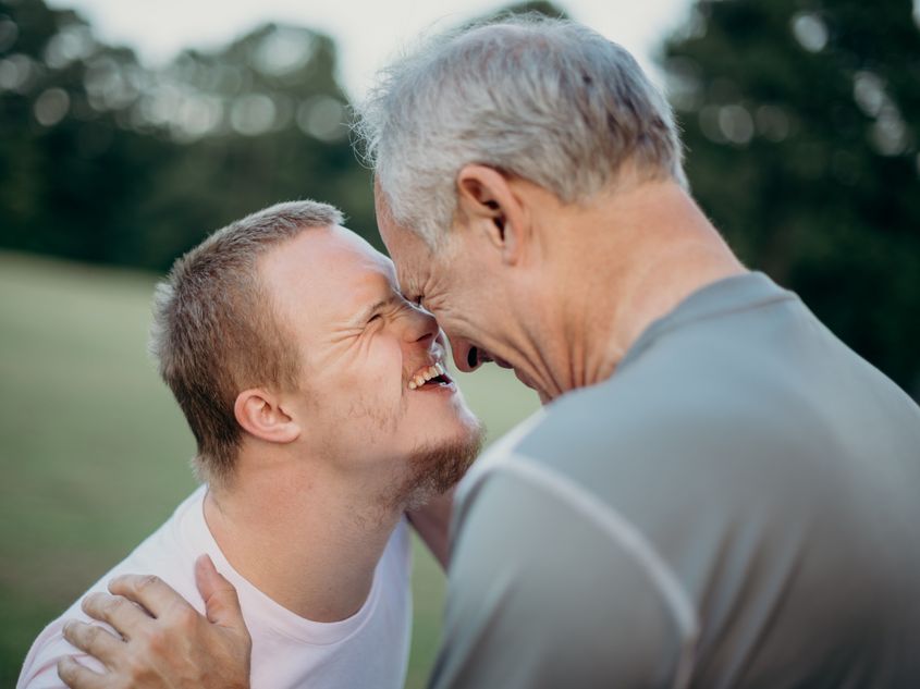 Junger Mann mit Downsyndrom, älterer Mann